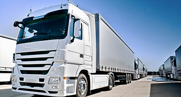 large white truck in a transport yard with multiple trucks visible featuring modern design and heavy duty capability